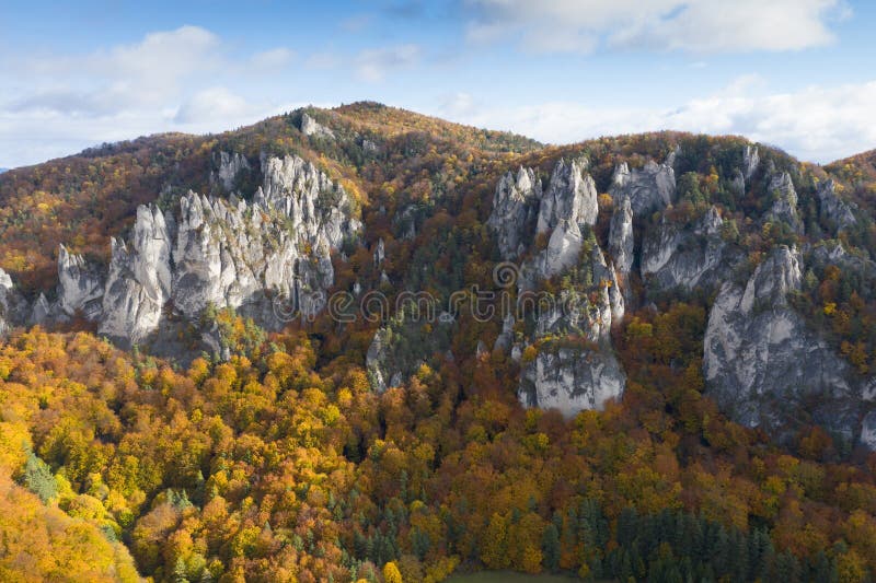 Scenic landscape in Sulov, Slovakia, on beautiful autumn sunrise with colorful leaves on trees in forest and bizarre pointy rocks