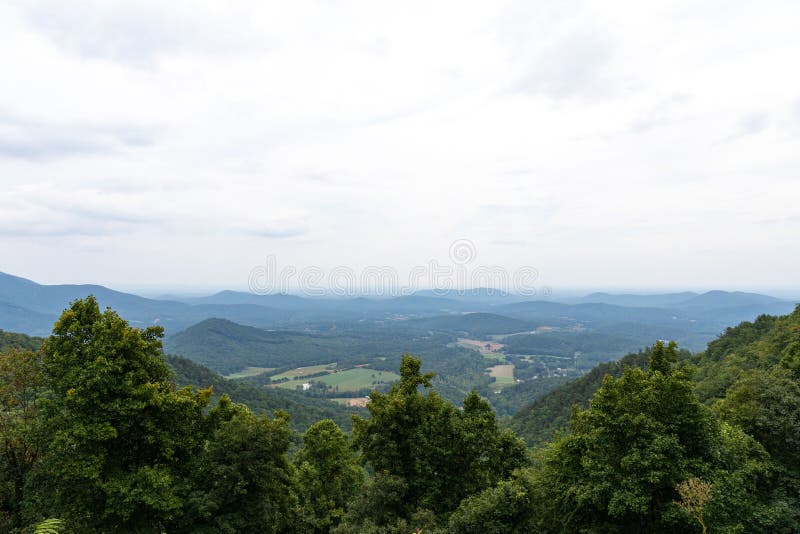 Scenic overlook of the Blue Ridge Mountains on a hazy, overcast day, deep green tree line in the foreground royalty free stock photos