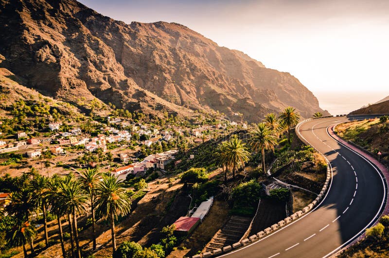 Scenic road in mountain landscape with sunset. Road trip. Beautiful nature and a small mountain village. Valle Gran Rey, La Gomera