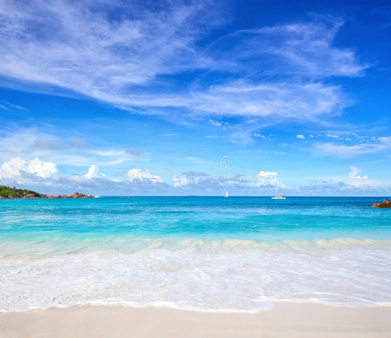 Scenic seascape with white sand on the beach and ocean`s turquoise water. Idyllic tropical beach scene. Seychelles.