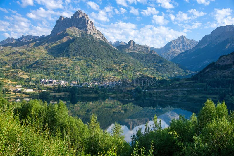 Scenic view of a green valley with a tranquil lake and majestic mountains in the Pyrenees, Spain. stock images