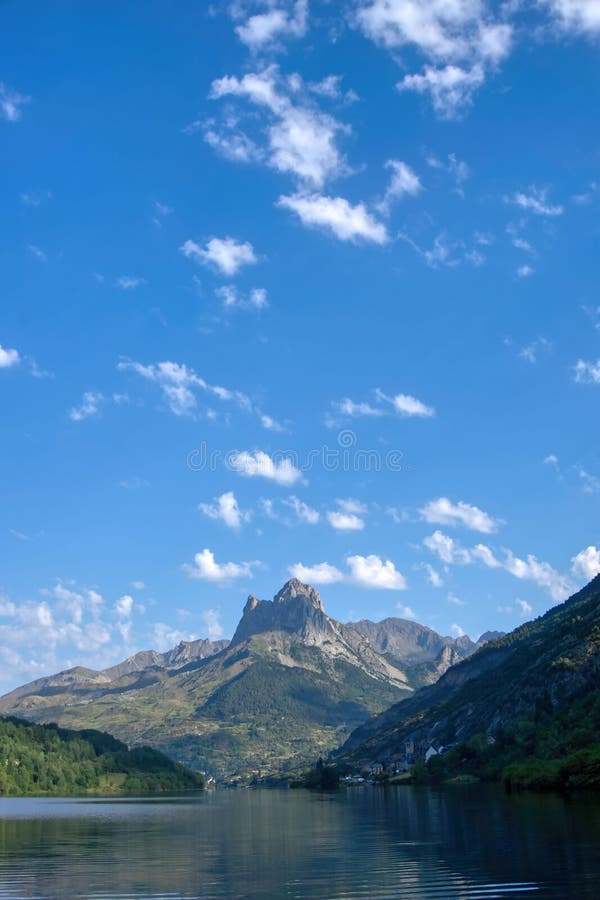 Scenic view of a green valley with a tranquil lake and majestic mountains in the Pyrenees, Spain. royalty free stock image