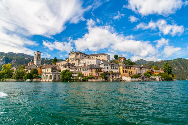 Scenic view from the lake of San Giulio Island, Orta`s Lake, Piemonte, Italy, with blue sky and white clouds. Scenic view from the lake of San Giulio Island, Orta`s Lake, Piemonte, Italy, with blue sky and white clouds.