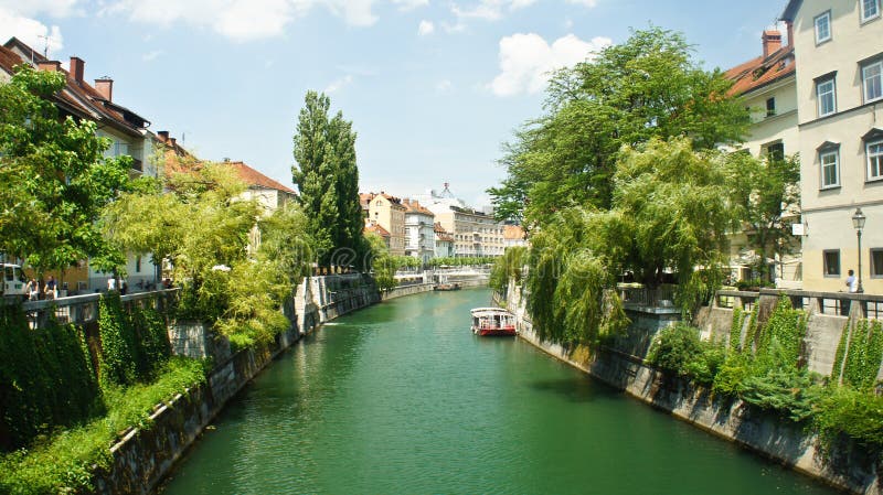 Scenic view of the Ljubljanica river in old town, cityscape with a green trees, beautiful architecture, sunny day, Ljubljana, stock photography Scenic view of the Ljubljanica river in old town, cityscape with a green trees, beautiful architecture, sunny day, Ljubljana, stock photography