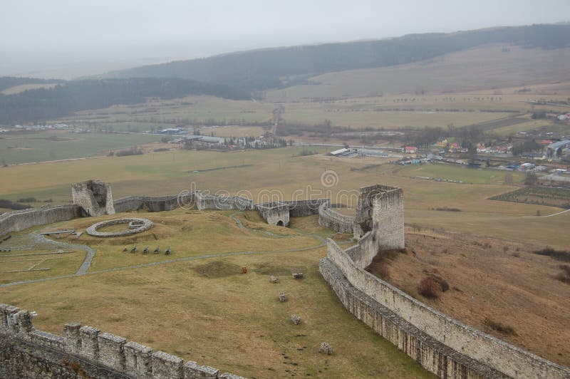 Scénický pohled na starý kamenný evropský hrad s šedou mlhou na pozadí