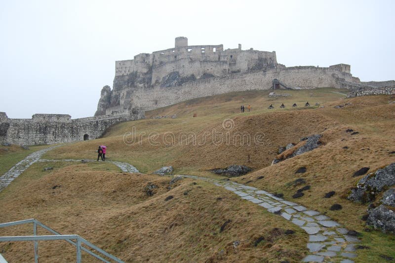 Scénický pohľad na starý kamenný európsky hrad so sivou hmlou na pozadí