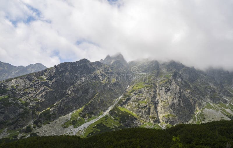 Scénický pohled na skalnaté mlžné hory proti zatažené obloze ve Vysokých Tatrách, Slovensko