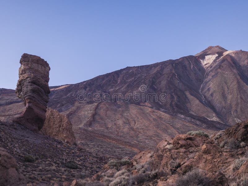 Scenic view at Roque Cinchado, volcanic rock formation and Pico del Teide volcano at El Teide national park in red sunset light colors. Tenerife Canary islands, Spain
