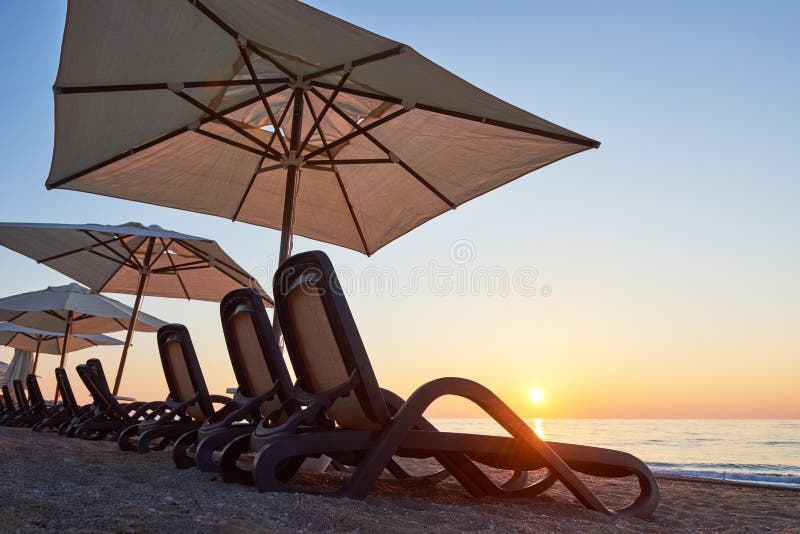 Scenic view of sandy beach on the beach with sun beds and umbrellas open against the sea and mountains. Hotel. Resort. Tekirova-Ke. Mer. Turkey royalty free stock photography Scenic view of sandy beach on the beach with sun beds and umbrellas open against the sea and mountains. Hotel. Resort. Tekirova-Ke. Mer. Turkey royalty free stock photography