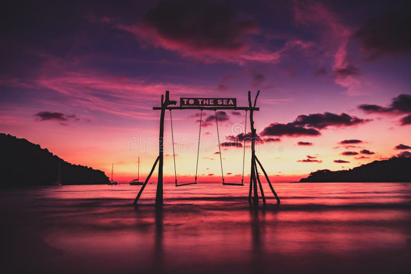 Sceniczne huśtawki w morzu dla kilka kochanków w miłości z pięknym zmierzchem fotografia stock Sceniczne huśtawki w morzu dla kilka kochanków w miłości z pięknym zmierzchem fotografia stock
