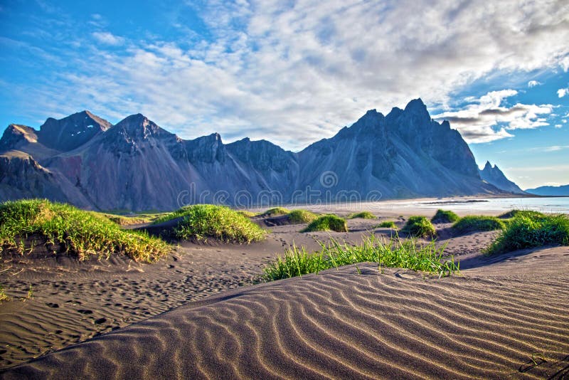 Sceniczny krajobraz z najwięcej breathtaking gór Vestrahorn na Stokksnes półwysepie i wygodna laguna z zieloną trawą na zdjęcia stock Sceniczny krajobraz z najwięcej breathtaking gór Vestrahorn na Stokksnes półwysepie i wygodna laguna z zieloną trawą na zdjęcia stock