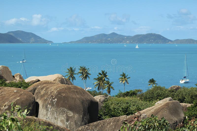 Sceniczny widok Z Wielkimi Granitowymi kamieniami, drzewkami palmowymi I Turkusową błękitne wody, Tortola, wyspy karaibskie fotografia stock Sceniczny widok Z Wielkimi Granitowymi kamieniami, drzewkami palmowymi I Turkusową błękitne wody, Tortola, wyspy karaibskie fotografia stock