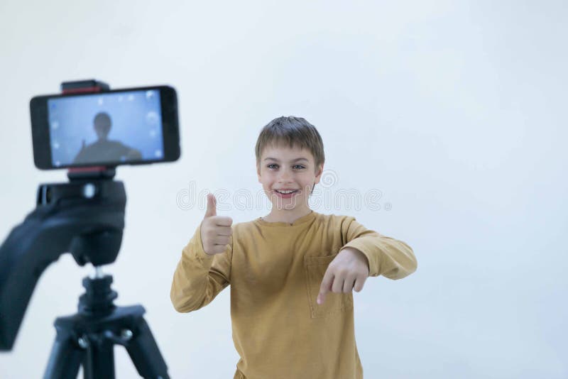 Sch?lergeneration Milenium steht an der Betonmauer in seinem Haus und schie?t Video, damit sein Kanal an setzt lizenzfreies stockfoto Sch?lergeneration Milenium steht an der Betonmauer in seinem Haus und schie?t Video, damit sein Kanal an setzt lizenzfreies stockfoto