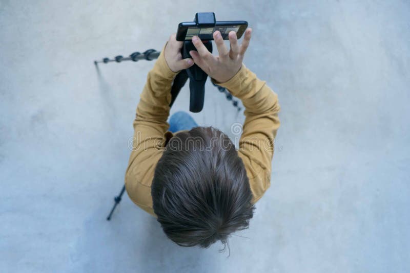 Sch?lergeneration Milenium steht an der Betonmauer in seinem Haus und schie?t Video, damit sein Kanal an setzt stockfoto Sch?lergeneration Milenium steht an der Betonmauer in seinem Haus und schie?t Video, damit sein Kanal an setzt stockfoto