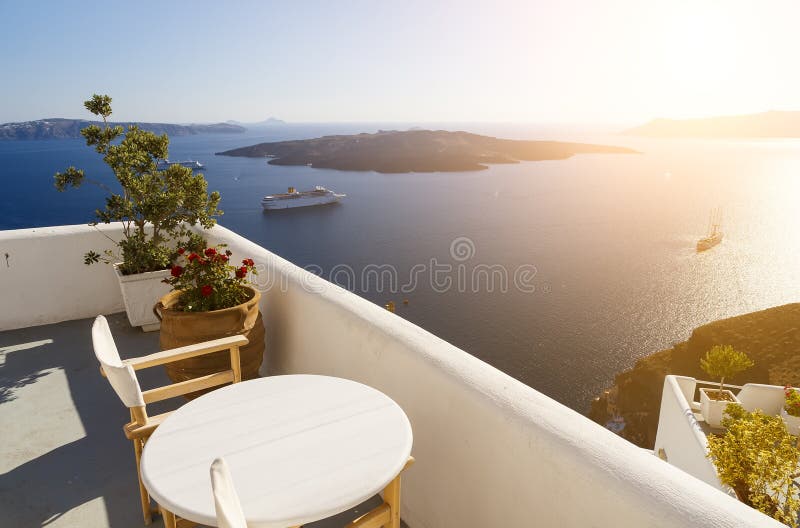 Sch?ner Sonnenuntergang in Santorini-Insel, Griechenland Zwei Stühle auf Terrasse mit Seeansicht lizenzfreies stockbild Sch?ner Sonnenuntergang in Santorini-Insel, Griechenland Zwei Stühle auf Terrasse mit Seeansicht lizenzfreies stockbild