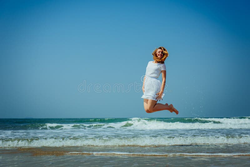 Sch?nes Joyfull-M?dchen, das auf den Strand springt Ferien und Entspannung stockbild Sch?nes Joyfull-M?dchen, das auf den Strand springt Ferien und Entspannung stockbild