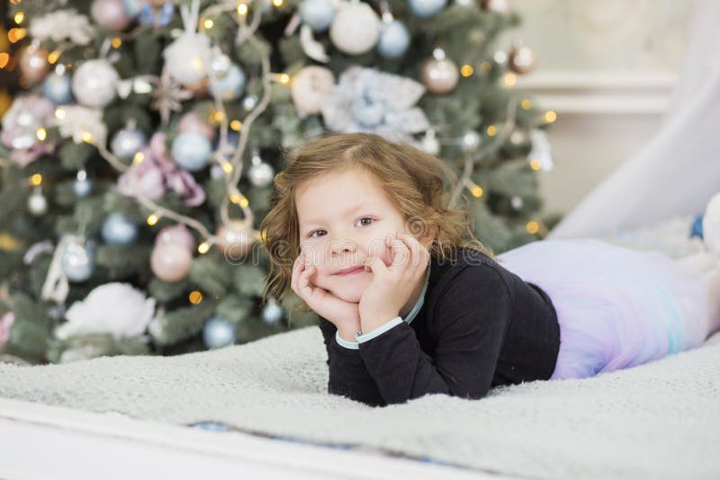 Sch? nes kleines M? dchen, das auf ein Wunder in den Weihnachtsdekorationen wartet stockfoto