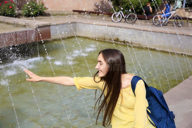 Sch? nes M? dchen, das mit einem Brunnen sich entspannt stockbilder