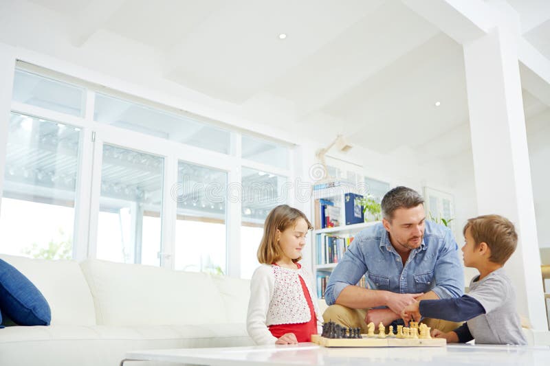 Schachplanung oder Strategie zusammen mit Vater und Kindern im Wohnzimmer für Maske oder Problemlösung. Gesellschaftsspiele lizenzfreie stockfotos