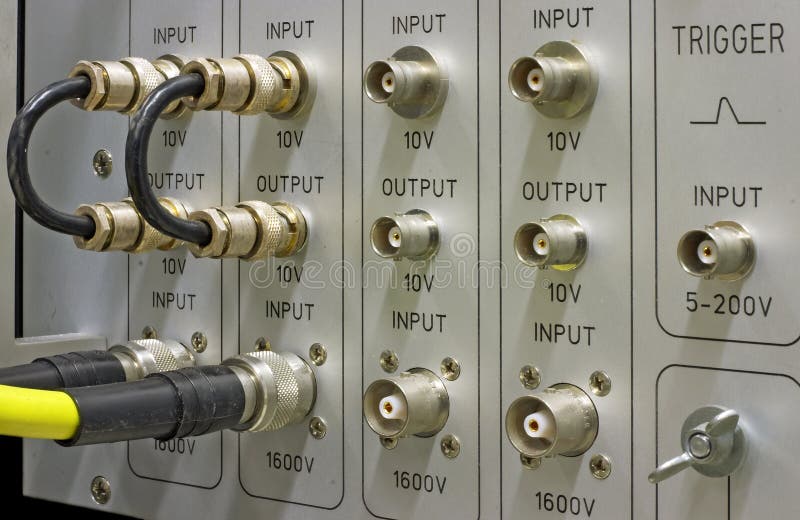 BNC connectors and cables on the front panel of a scientific measurement instrument. BNC connectors and cables on the front panel of a scientific measurement instrument