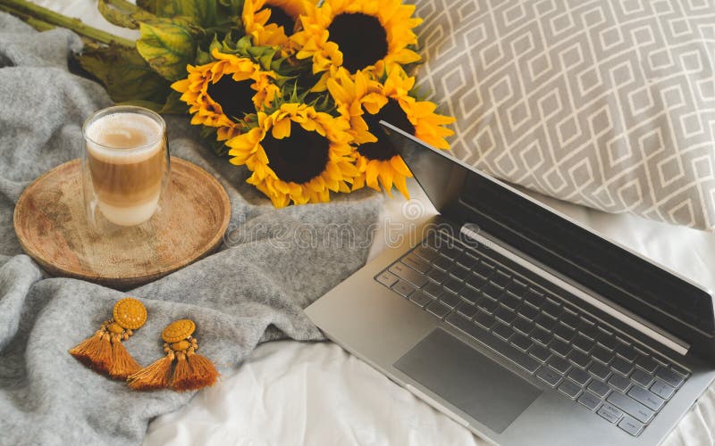 Cup with hot cappuccino, gray pastel woolen blanket, sunflowers, bedroom, morning concept. Cup with hot cappuccino, gray pastel woolen blanket, sunflowers, bedroom, morning concept