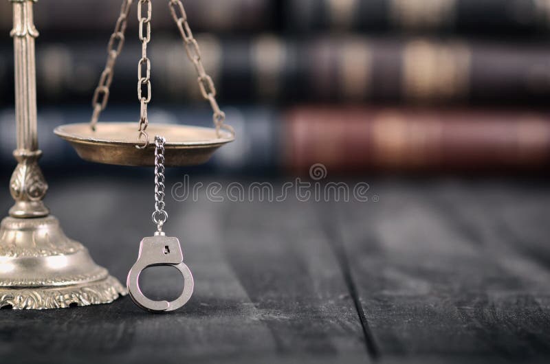 Schalen van Rechtvaardigheid en handcuffs op een zwarte houten achtergrond stock afbeelding Schalen van Rechtvaardigheid en handcuffs op een zwarte houten achtergrond stock afbeelding