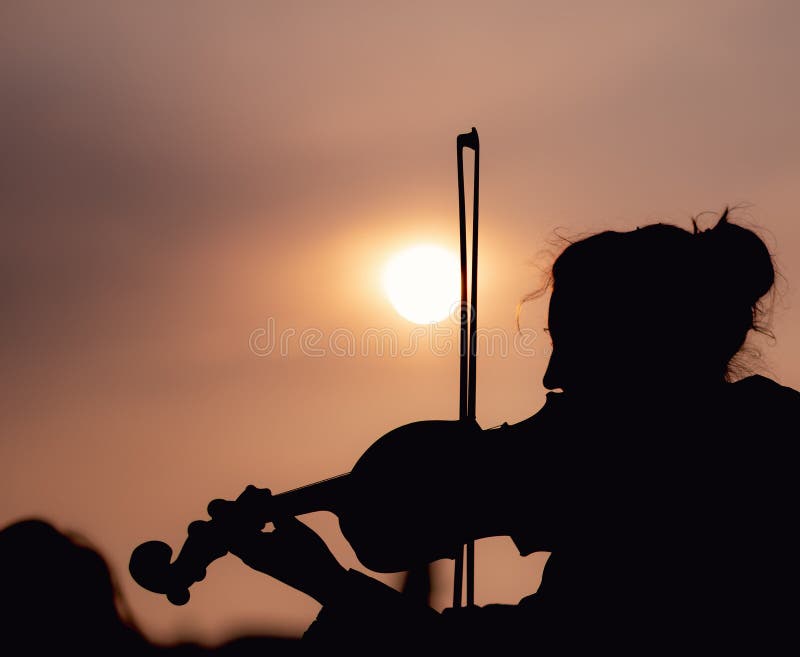 Schattenbild der Frau die Violine während des Sonnenuntergangs gegen das sonnen- eingelassene Prag spielend lizenzfreie stockfotografie Schattenbild der Frau die Violine während des Sonnenuntergangs gegen das sonnen- eingelassene Prag spielend lizenzfreie stockfotografie