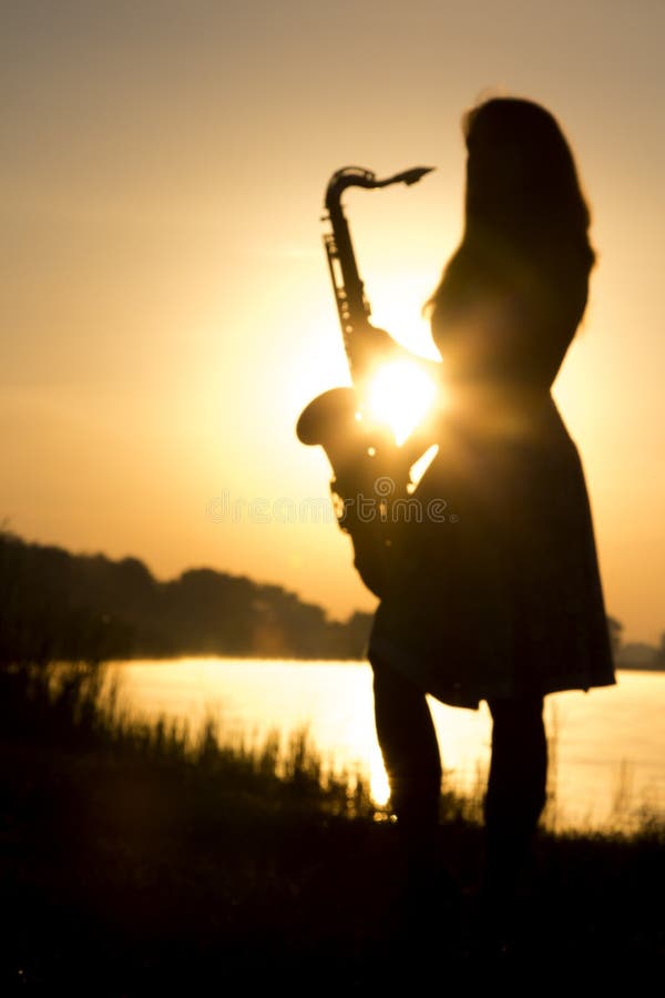 Schattenbild der Frau mit einem Blasinstrument in den Händen in der Natur lizenzfreie stockfotos Schattenbild der Frau mit einem Blasinstrument in den Händen in der Natur lizenzfreie stockfotos