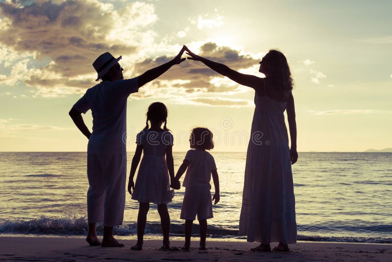 Schattenbild der glücklichen Familie das, die auf dem Strand am sunse spielt stockbild Schattenbild der glücklichen Familie das, die auf dem Strand am sunse spielt stockbild