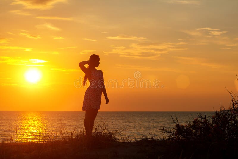 Schattenbild einer jungen Frau auf dem Strand bei Sonnenuntergang lizenzfreies stockfoto Schattenbild einer jungen Frau auf dem Strand bei Sonnenuntergang lizenzfreies stockfoto