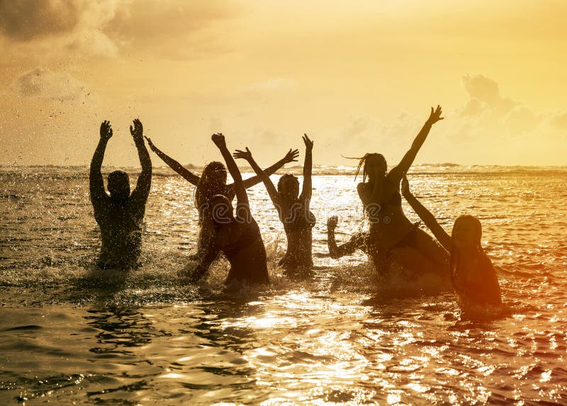 Schattenbilder der Leute, die in Ozean springen stockbild Schattenbilder der Leute, die in Ozean springen stockbild
