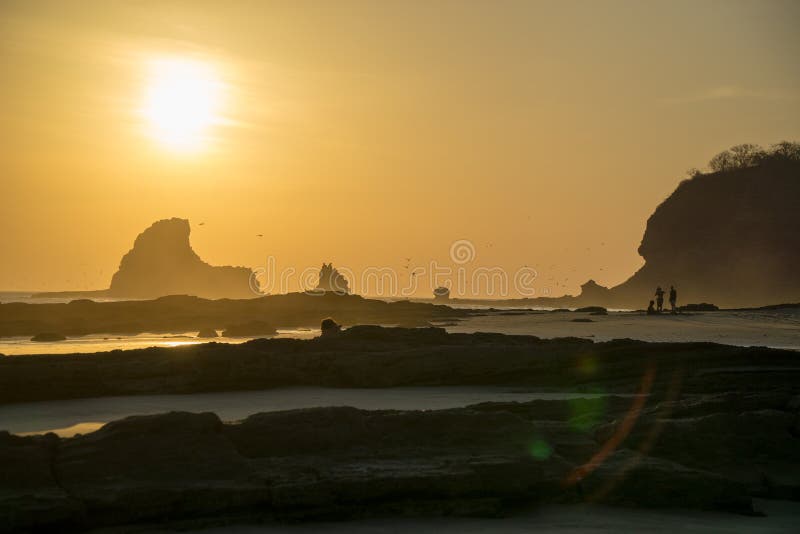 Schattenbilder von den Leuten, die mit dem Sonnenuntergang dem Strand betrachten Mit Reflexionen und Vögeln im Himmel lizenzfreie stockbilder Schattenbilder von den Leuten, die mit dem Sonnenuntergang dem Strand betrachten Mit Reflexionen und Vögeln im Himmel lizenzfreie stockbilder