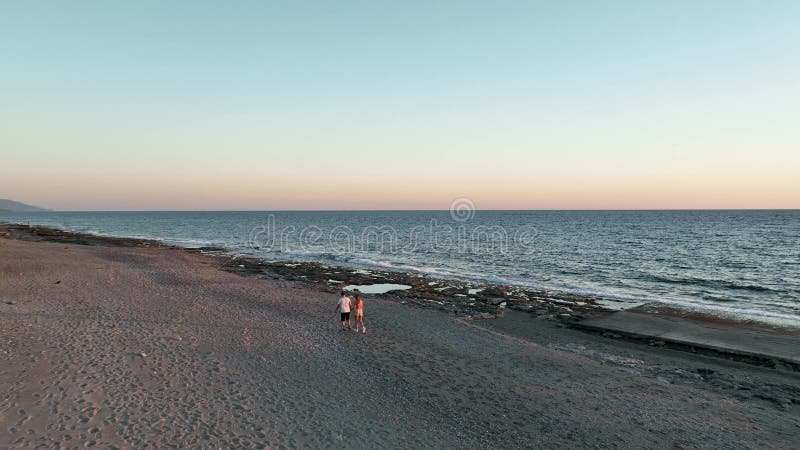 Schattig stel dat op zonsondergang 4.000 op het strand loopt