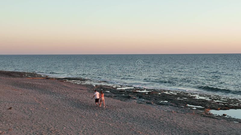 Schattig stel dat op zonsondergang 4.000 op het strand loopt