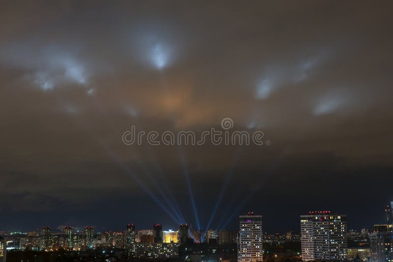 Scheinwerfer glänzen im nächtlichen Himmel über der Stadt