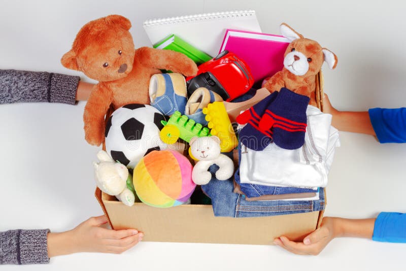 Schenkingsconcept De jong geitjehanden met schenken vakje met kleren, boeken, schoollevering en speelgoed, witte achtergrond royalty-vrije stock fotografie Schenkingsconcept De jong geitjehanden met schenken vakje met kleren, boeken, schoollevering en speelgoed, witte achtergrond royalty-vrije stock fotografie