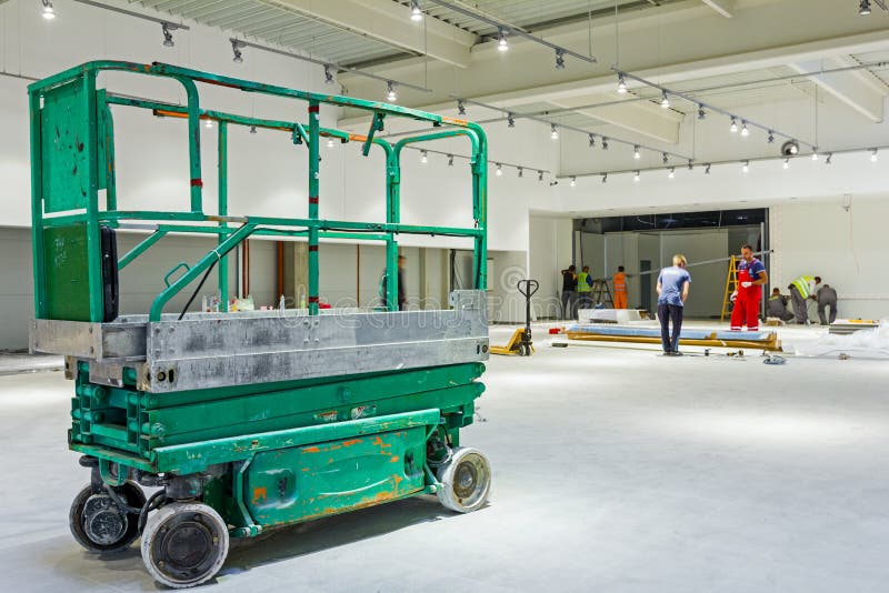 Scherenhebebühneplattform auf einer Baustelle lizenzfreies stockfoto Scherenhebebühneplattform auf einer Baustelle lizenzfreies stockfoto