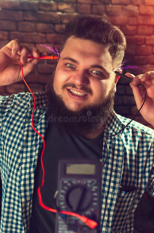 Scherzi maschii del tecnico di assistenza con il multimetro immagini stock