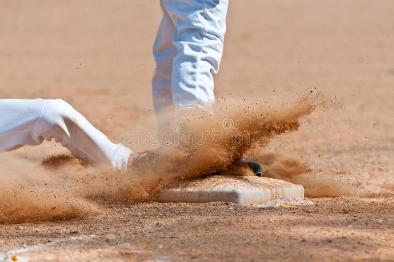 Base runner sliding into third base, close up on base. Base runner sliding into third base, close up on base