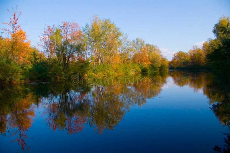 Schilderachtig de herfstlandschap van rivier en heldere bomen royalty-vrije stock afbeelding Schilderachtig de herfstlandschap van rivier en heldere bomen royalty-vrije stock afbeelding
