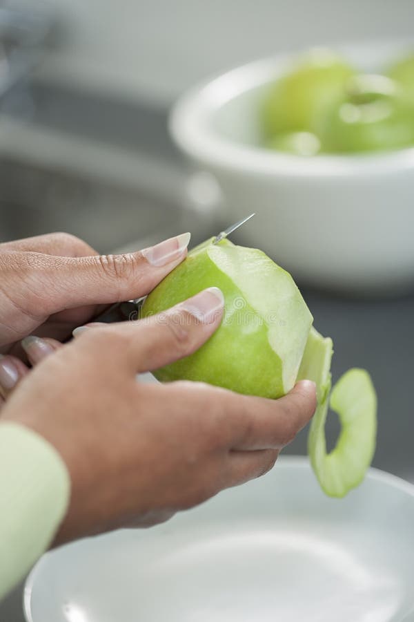 Schilhuid weg van een groene appel die een het knippen mes gebruiken royalty-vrije stock afbeeldingen Schilhuid weg van een groene appel die een het knippen mes gebruiken royalty-vrije stock afbeeldingen