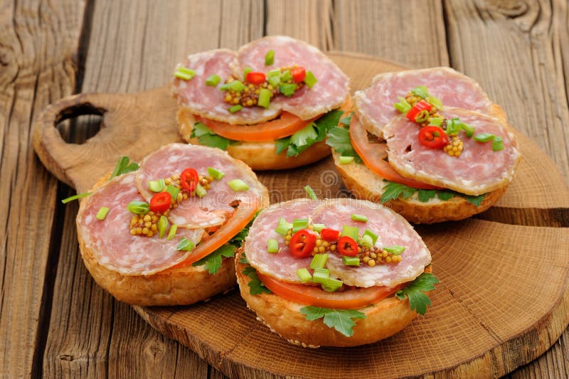 Schinkensandwiche mit Paprika, Petersilie und Schalotte auf hölzernem Brett stockbild Schinkensandwiche mit Paprika, Petersilie und Schalotte auf hölzernem Brett stockbild