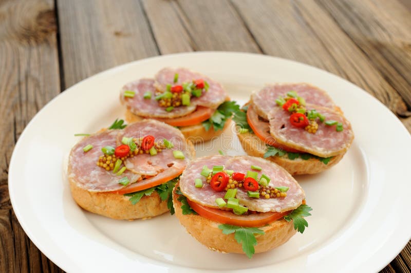 Schinkensandwiche mit Paprika, Petersilie und Schalotte auf weißer Platte lizenzfreies stockbild Schinkensandwiche mit Paprika, Petersilie und Schalotte auf weißer Platte lizenzfreies stockbild