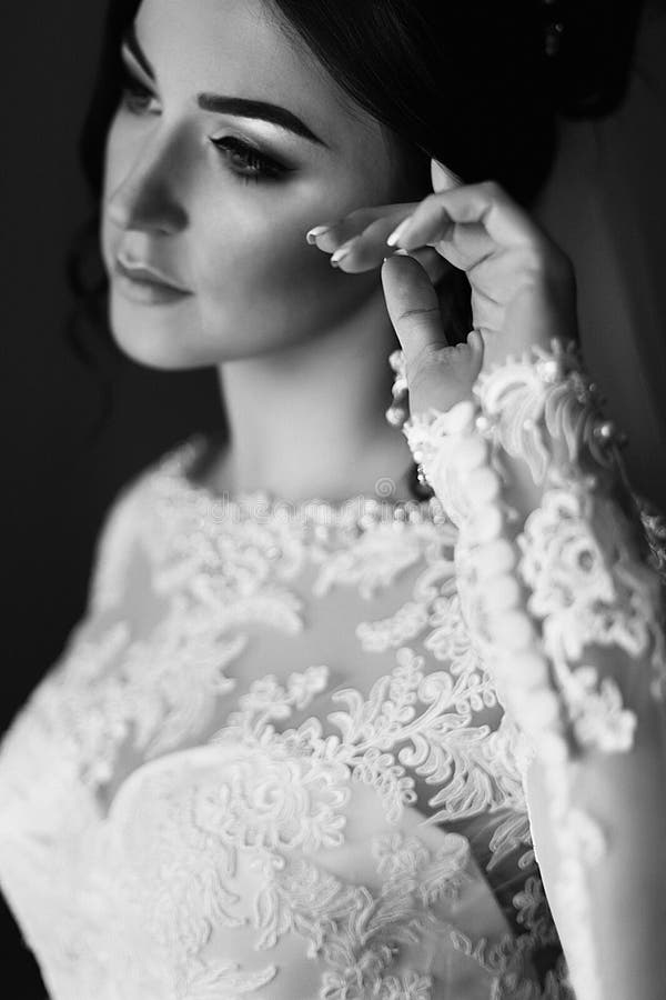 Schitterende donkerbruine bruid die binnenhotelruimte stellen vóór ceremonie stock fotografie Schitterende donkerbruine bruid die binnenhotelruimte stellen vóór ceremonie stock fotografie