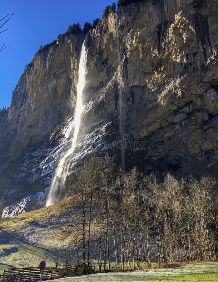 Schitterende waterval bij beroemde Lauterbrunnen-vallei en Zwitserse Alpen met zonlichtbezinning in wintertijd royalty-vrije stock afbeelding Schitterende waterval bij beroemde Lauterbrunnen-vallei en Zwitserse Alpen met zonlichtbezinning in wintertijd royalty-vrije stock afbeelding