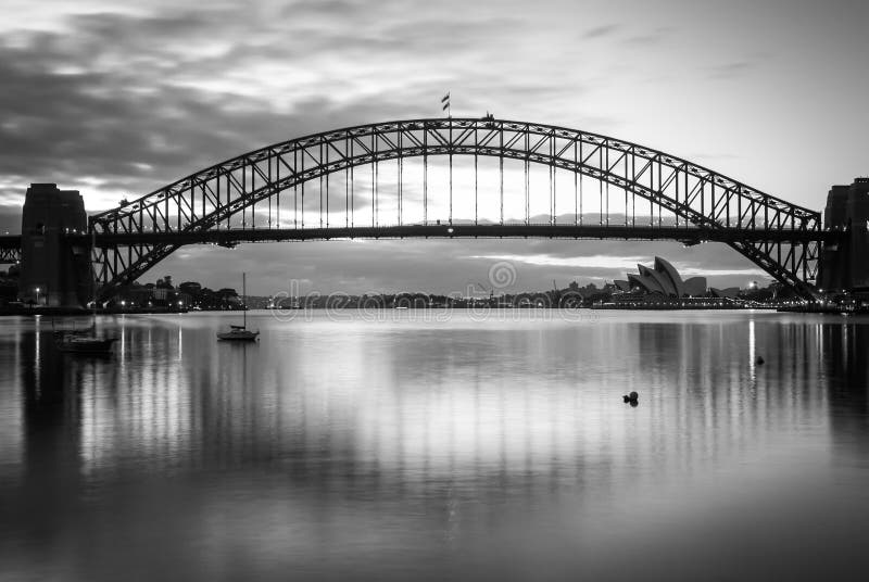 Schitterende zonsondergang die op de machtige brug van staalsydney harbor de oceaan kruisen stock foto's Schitterende zonsondergang die op de machtige brug van staalsydney harbor de oceaan kruisen stock foto's