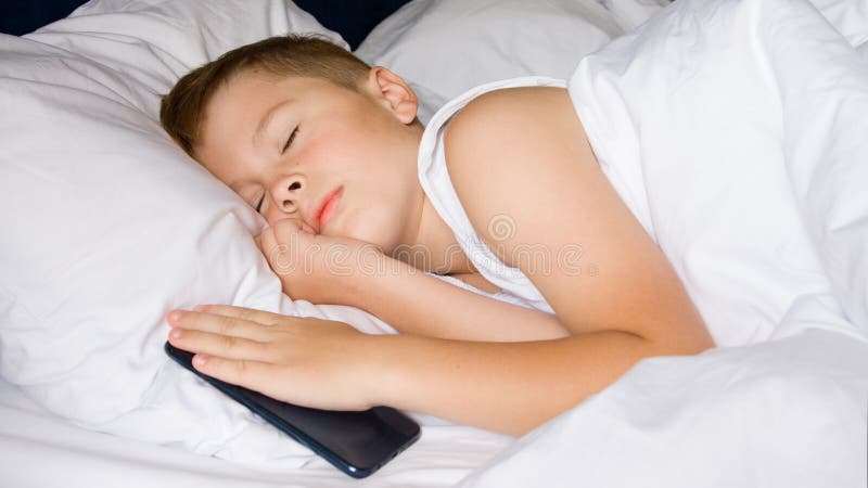 Schlafender Teenager-Junge hält sein Smartphone Gadget-Abhängigkeit stockfotos Schlafender Teenager-Junge hält sein Smartphone Gadget-Abhängigkeit stockfotos
