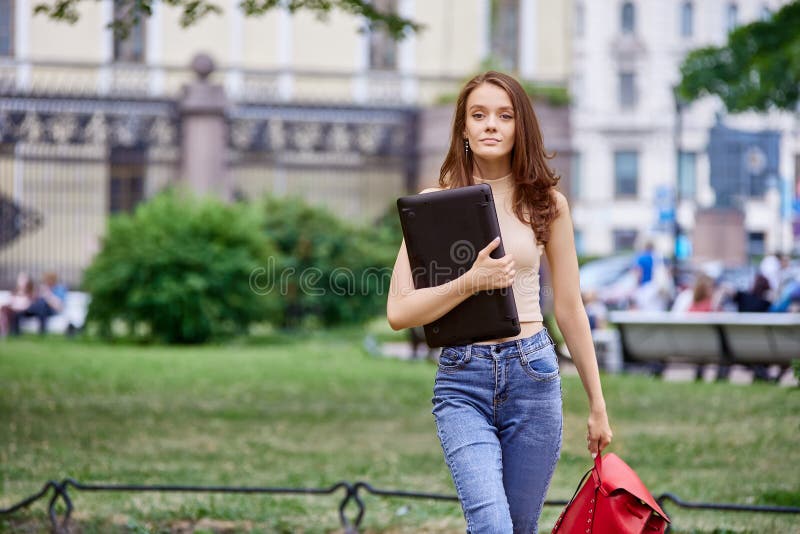 Schlanke 18-jährige Schüler kam zum Park mit Laptop. stockbild