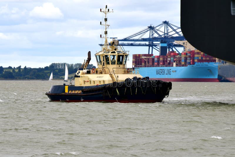 Schlepper führen heraus ein Containerschiff vom Hafen von Felixstowe Großbritannien lizenzfreie stockfotografie Schlepper führen heraus ein Containerschiff vom Hafen von Felixstowe Großbritannien lizenzfreie stockfotografie