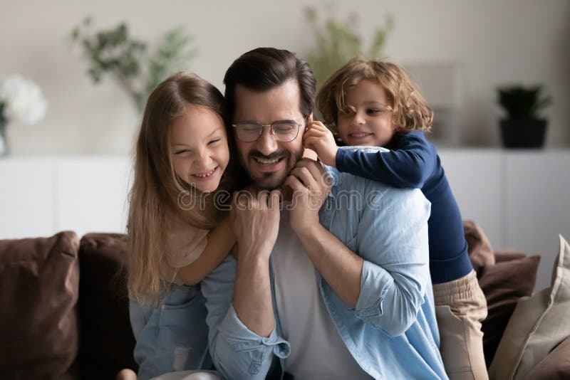 Schließen Sie glücklichen Vater mit Kindern, die sich auf der Couch amüsieren lizenzfreies stockbild